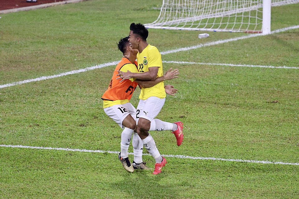 Boletos de apuestas deportivas junto a un balón de fútbol